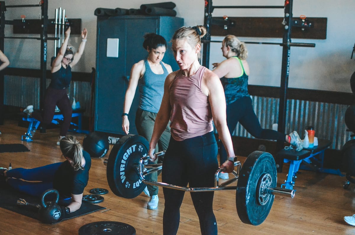 An energetic in-studio group workout at SweatLocal, members mid-session